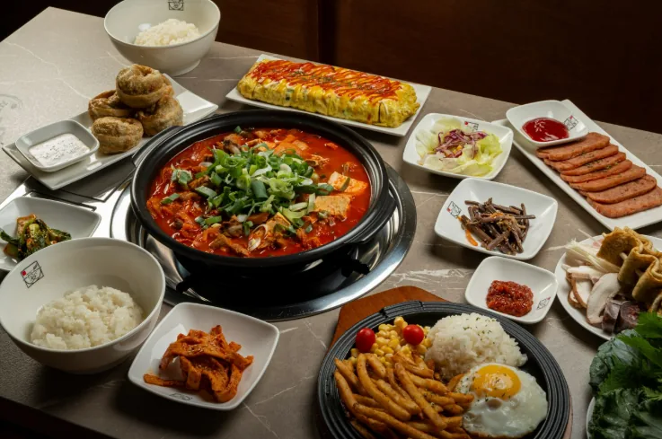 쌀밥애 찌개담다 김치찌개와 밥, 반찬, 추가 메뉴가 놓인 한상 사진